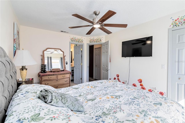 bedroom featuring a ceiling fan, visible vents, and a textured ceiling