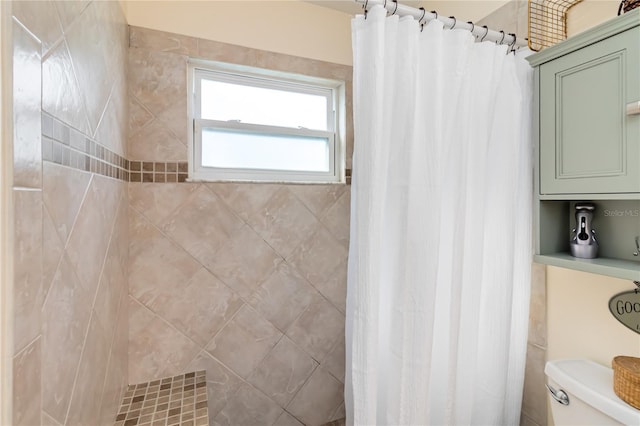 full bath featuring toilet and a tile shower