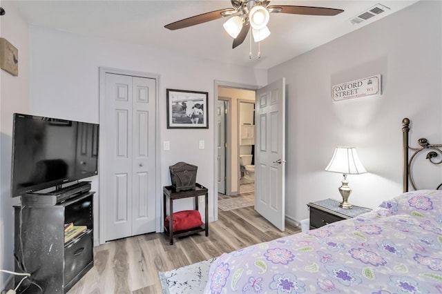 bedroom with light wood-style floors, a ceiling fan, visible vents, and a closet