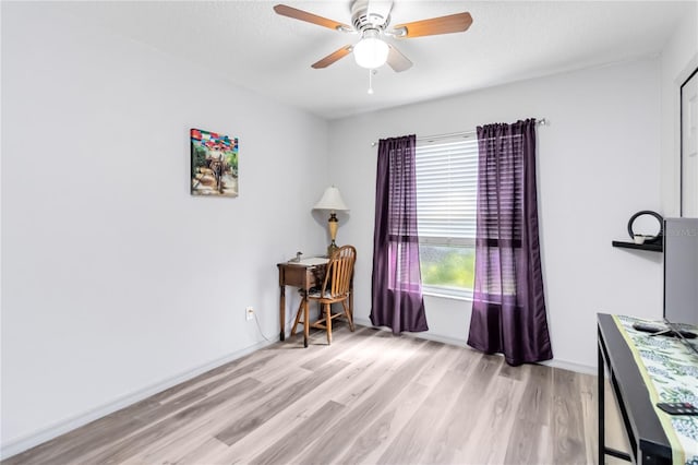 home office featuring ceiling fan, a textured ceiling, baseboards, and wood finished floors