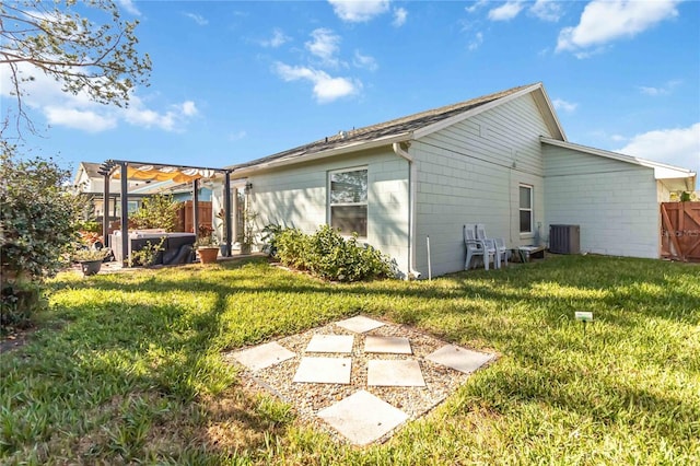 rear view of house with a lawn, fence, cooling unit, and a pergola