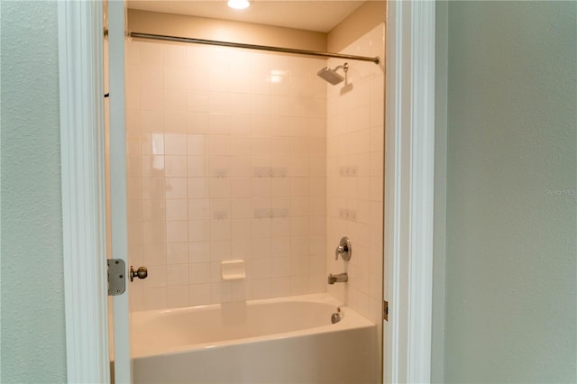 bathroom featuring shower / washtub combination and a textured wall