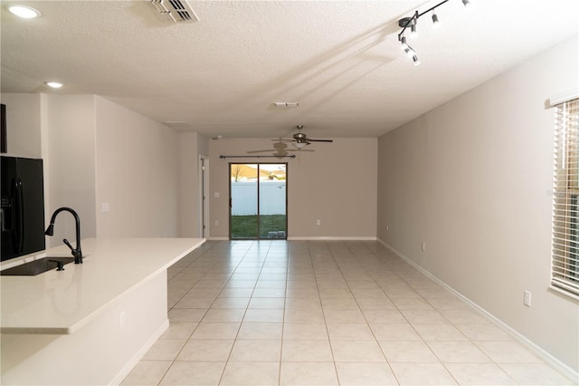 living area with a healthy amount of sunlight, light tile patterned floors, visible vents, and a ceiling fan