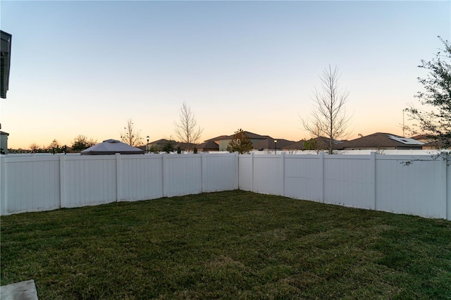 yard at dusk with a fenced backyard