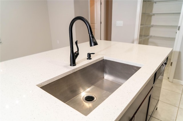 details featuring light stone countertops and a sink