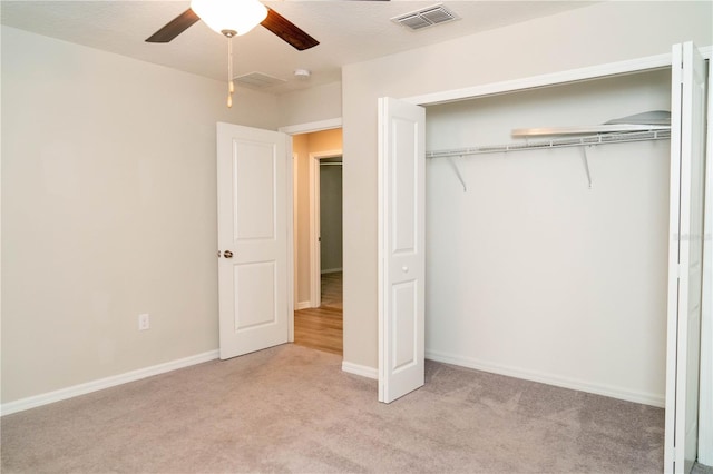 unfurnished bedroom featuring light carpet, a closet, visible vents, and baseboards