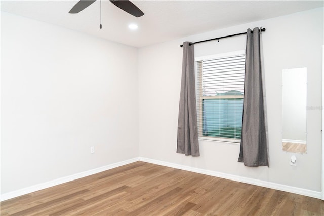 empty room featuring a ceiling fan, baseboards, and wood finished floors