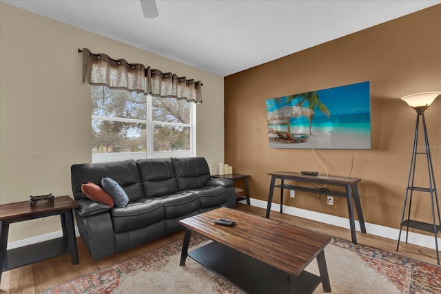 living area with baseboards and wood finished floors