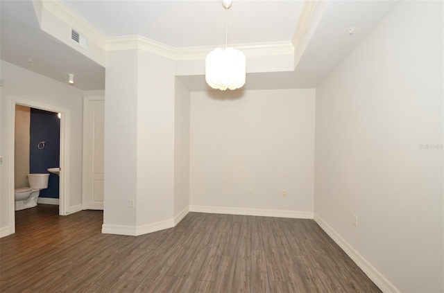 spare room featuring ornamental molding, visible vents, dark wood finished floors, and baseboards