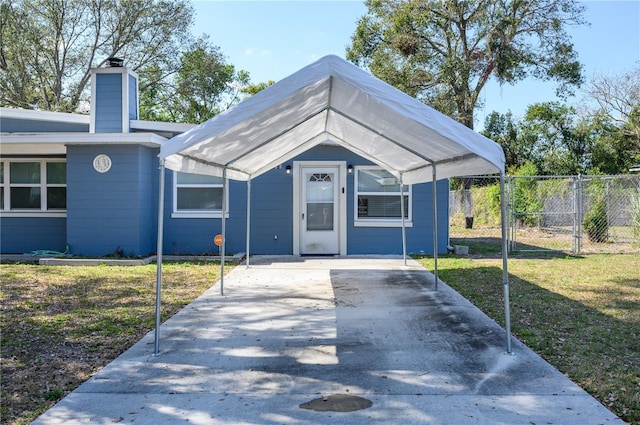 1006 San Domingo Rd, Orlando, FL 32808 - view of front of house featuring driveway, a chimney, fence, a carport, and a front yard