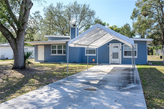 1006 San Domingo Rd, Orlando, FL 32808 - view of front facade featuring a chimney, concrete driveway, and a front yard