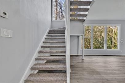 stairs featuring wood finished floors and baseboards