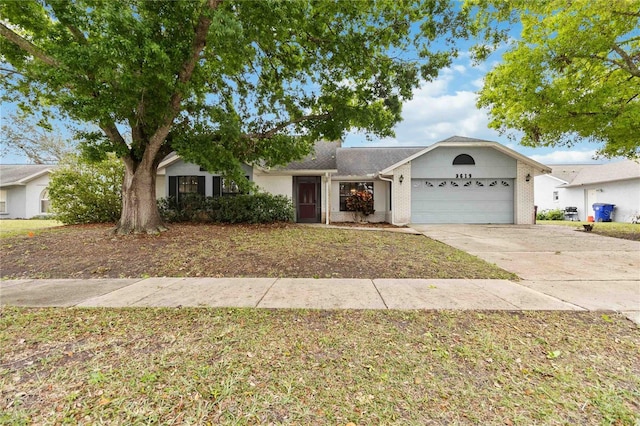 single story home featuring a garage, driveway, brick siding, and a front lawn