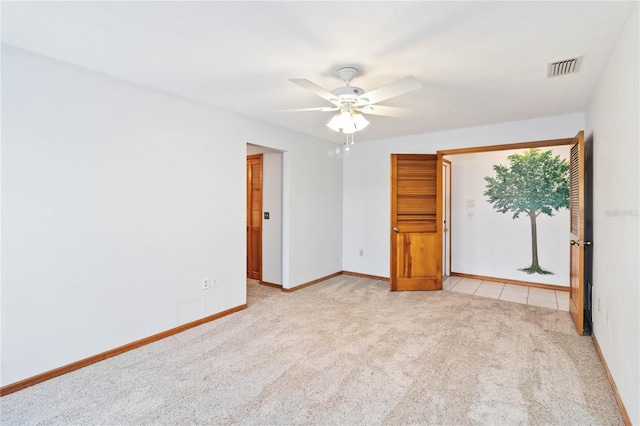 spare room with light carpet, baseboards, visible vents, and a ceiling fan