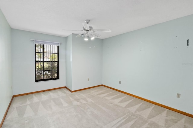 empty room featuring light carpet, ceiling fan, and baseboards