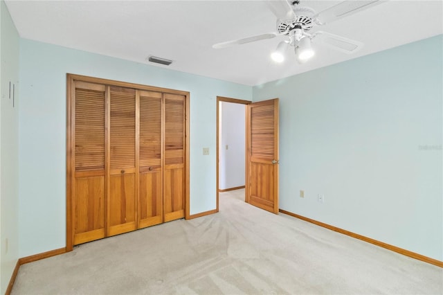 unfurnished bedroom featuring a closet, light colored carpet, visible vents, a ceiling fan, and baseboards