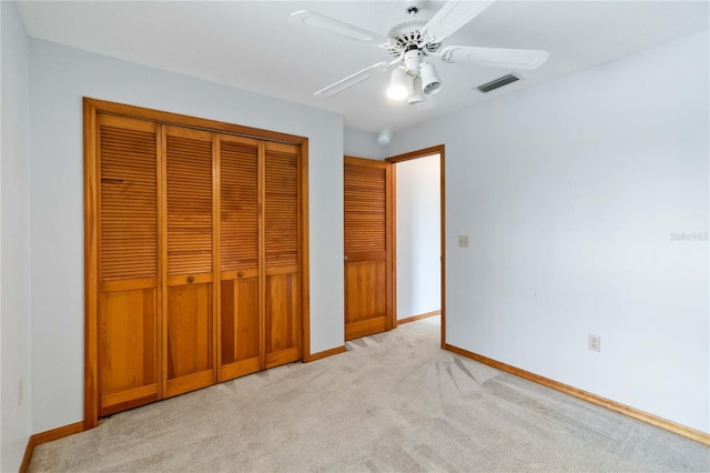 unfurnished bedroom featuring light carpet, a closet, visible vents, and baseboards