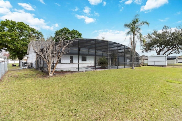 back of house with a lanai, a fenced backyard, and a yard