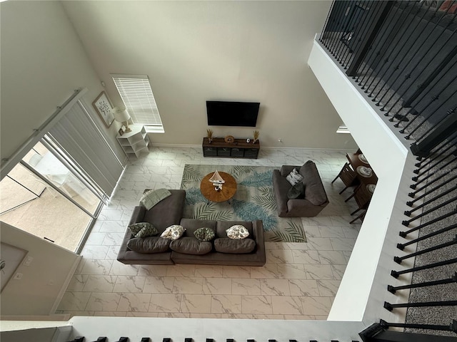 living area featuring marble finish floor, a high ceiling, and stairway