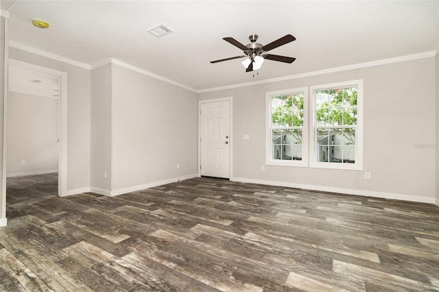 empty room featuring ornamental molding, dark wood finished floors, and baseboards