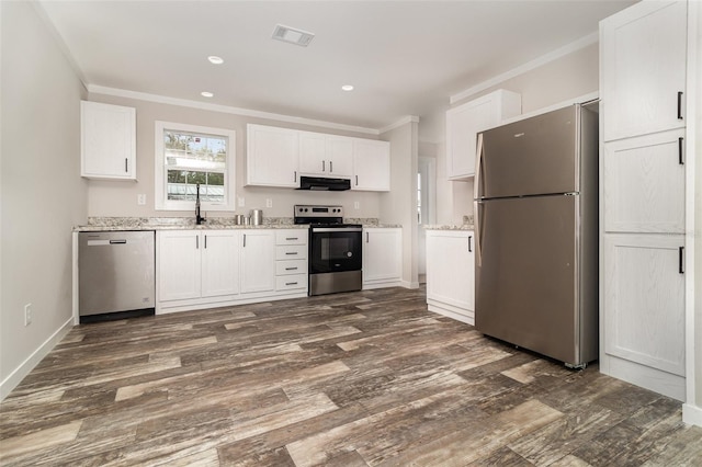 kitchen featuring under cabinet range hood, white cabinetry, stainless steel appliances, and a sink