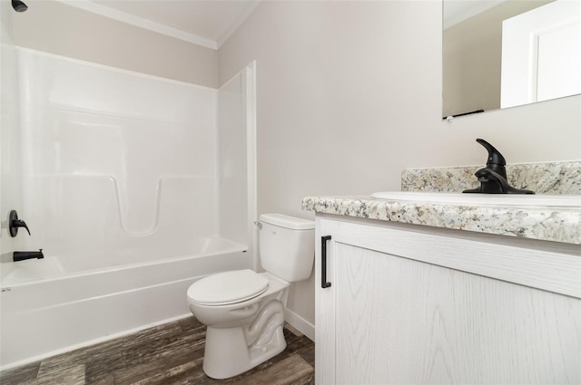 bathroom featuring bathtub / shower combination, toilet, wood finished floors, vanity, and crown molding