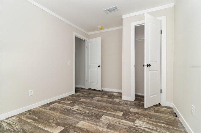 unfurnished bedroom featuring crown molding, a closet, visible vents, dark wood-type flooring, and baseboards