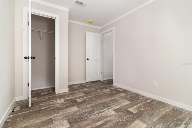 unfurnished bedroom featuring dark wood-style floors, baseboards, visible vents, and crown molding