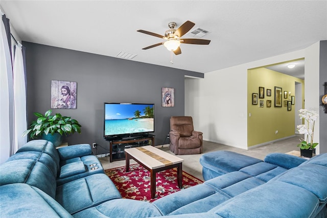 living room with light colored carpet, visible vents, ceiling fan, and baseboards