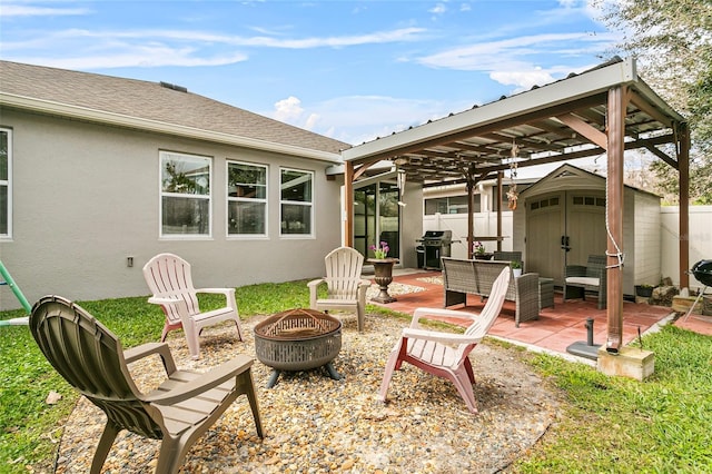 view of patio / terrace featuring a storage shed, an outdoor fire pit, an outdoor structure, and fence