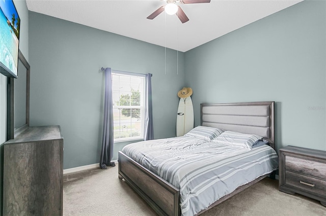 bedroom with light carpet, ceiling fan, and baseboards