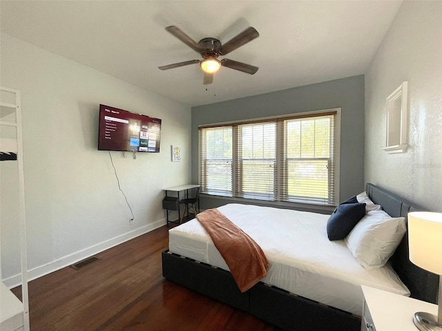 bedroom with dark wood-style floors, visible vents, baseboards, and a ceiling fan