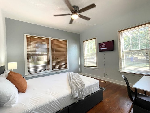 bedroom with a ceiling fan, baseboards, and dark wood-style flooring