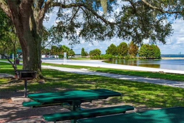 view of home's community with a lawn and a water view