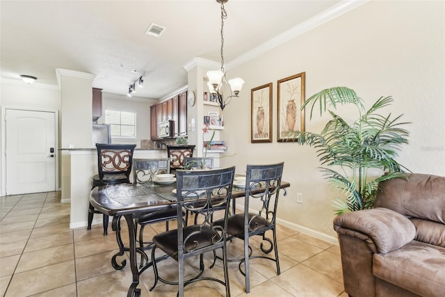 dining room with a chandelier, ornamental molding, light tile patterned floors, and visible vents