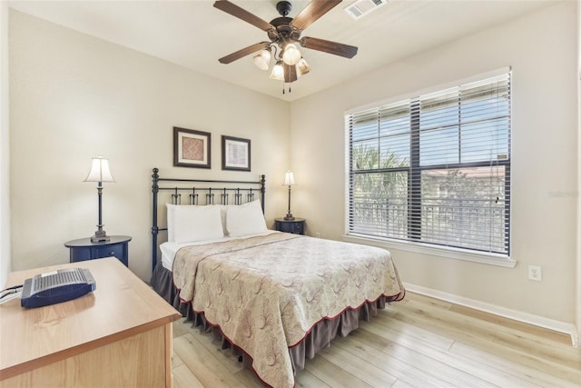 bedroom featuring baseboards, ceiling fan, visible vents, and light wood-style floors