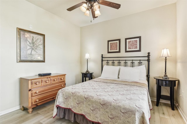 bedroom with light wood-type flooring, a ceiling fan, and baseboards