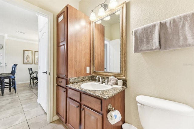 bathroom with visible vents, toilet, ornamental molding, vanity, and tile patterned flooring