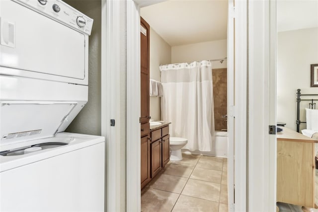 laundry area featuring stacked washing maching and dryer, light tile patterned floors, and laundry area