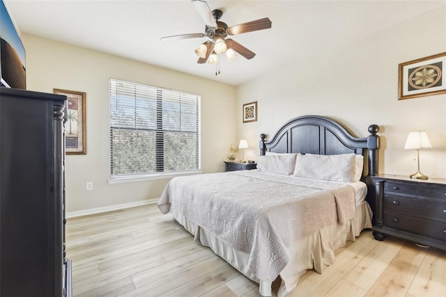 bedroom with light wood-type flooring, baseboards, and a ceiling fan