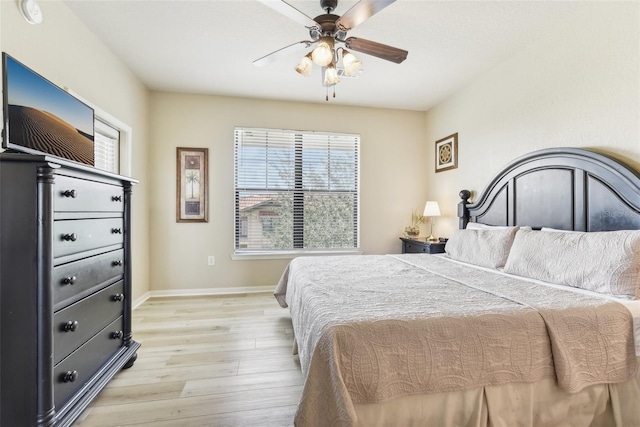 bedroom featuring light wood-style floors, ceiling fan, and baseboards