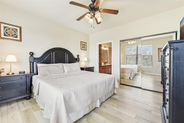 bedroom featuring a ceiling fan, light wood-type flooring, baseboards, and ensuite bath