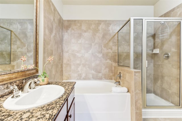 full bathroom featuring a stall shower, a garden tub, and vanity