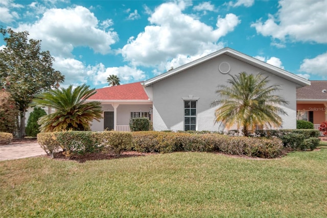 318 Rock Springs Dr, Poinciana, FL 34759 - view of home's exterior featuring stucco siding, a yard, and a shingled roof
