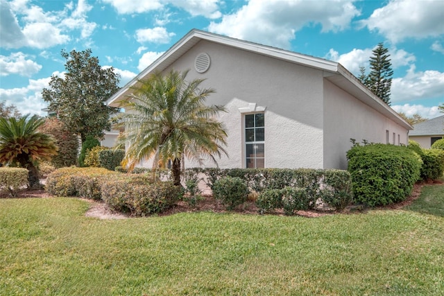 318 Rock Springs Dr, Poinciana, FL 34759 - view of property exterior featuring stucco siding and a lawn