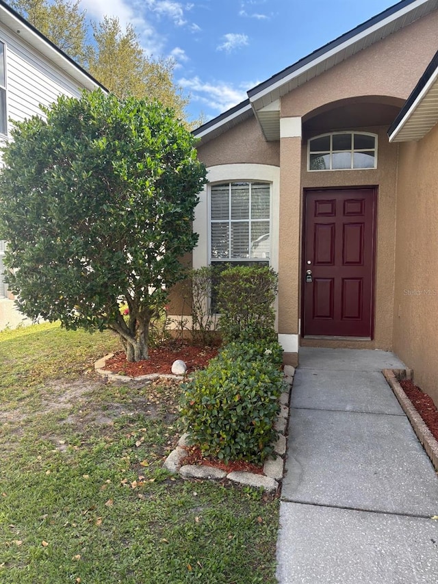 entrance to property with stucco siding