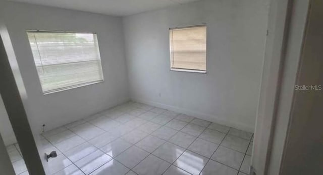 empty room featuring light tile patterned flooring and plenty of natural light