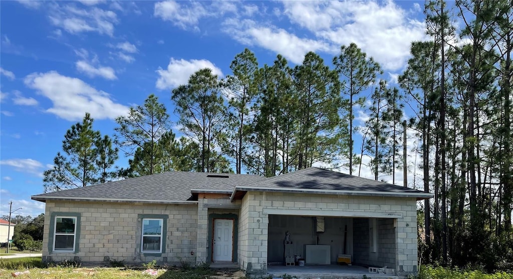 view of front of house featuring a garage, driveway, and a shingled roof