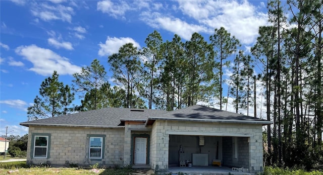 view of front of house featuring a garage, driveway, and a shingled roof