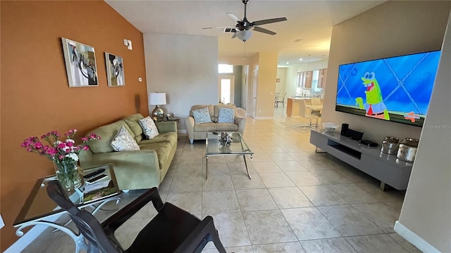 living room with light tile patterned floors, ceiling fan, and baseboards